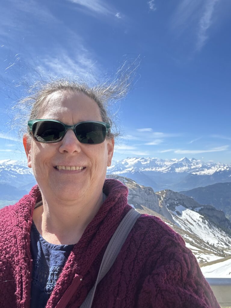 Karen, the owner of Build a Life That's Yours on the top of the Swiss Alps